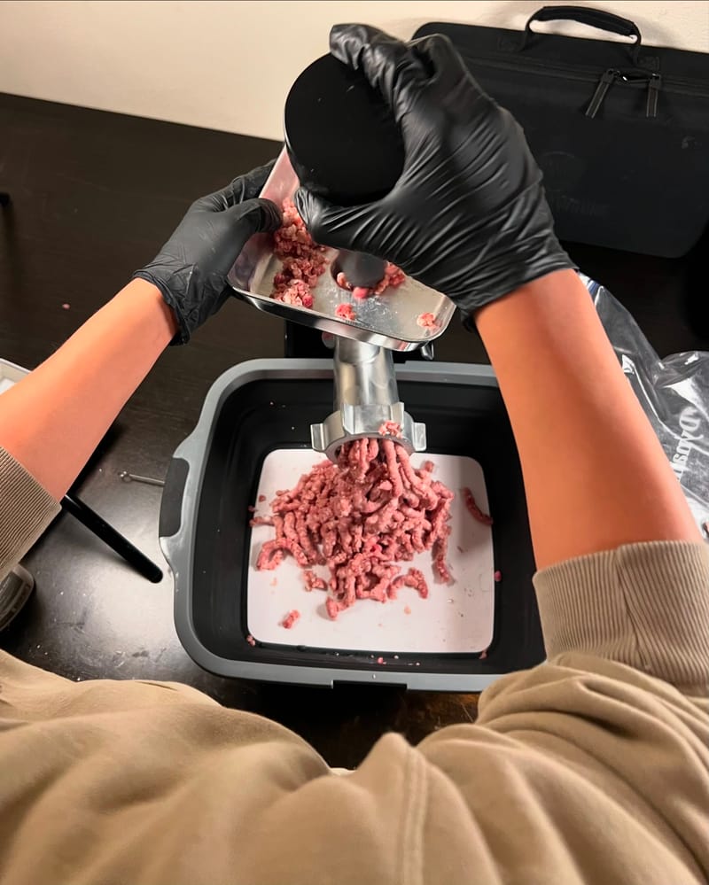 Teaching the Backyahd Kid how to grind brisket trim into burger meat. He’s a quick study.