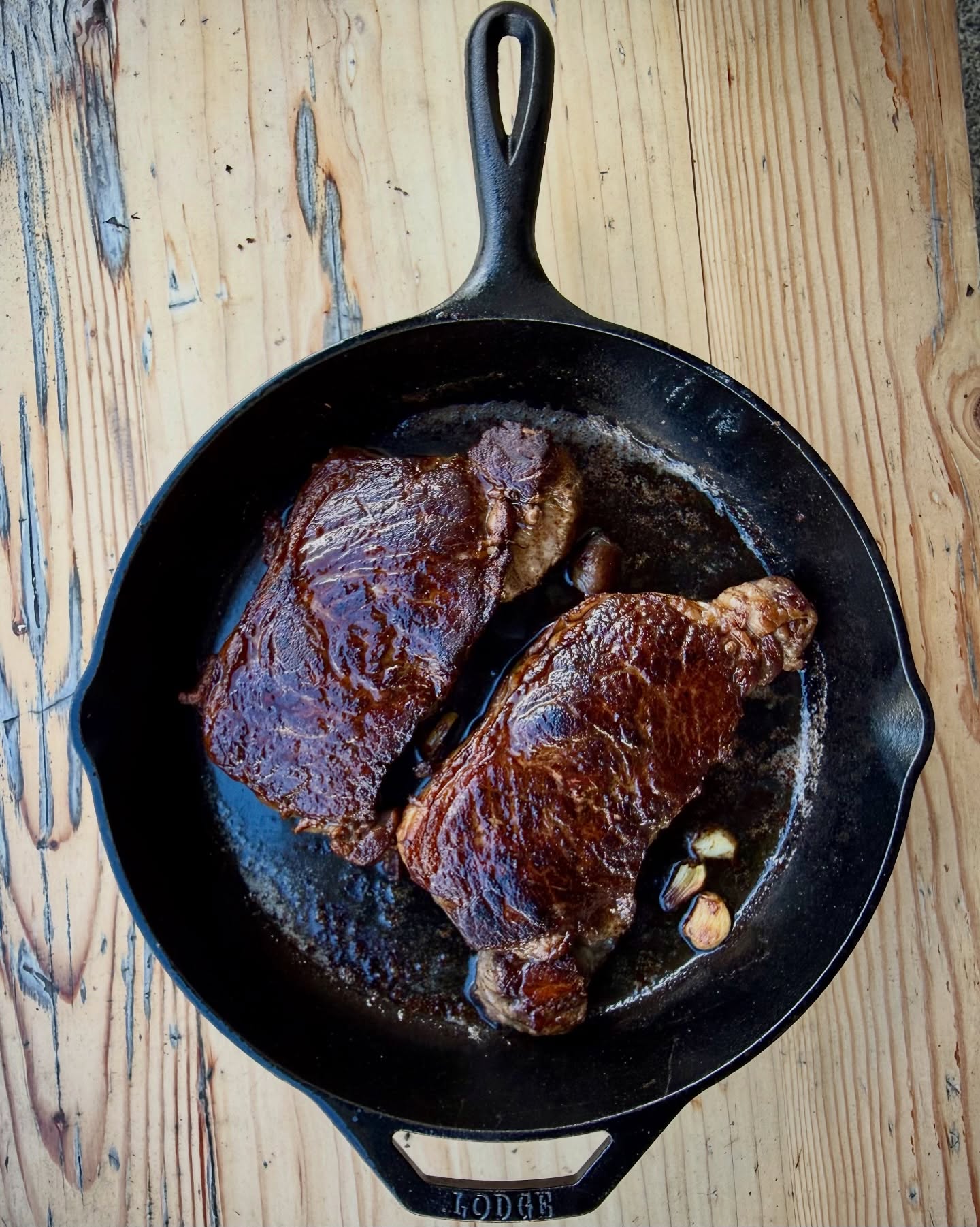 Steaks on @lodgecastiron. 500F each side with a weight for good contact until good crust. Butter and garlic baste. Finish in oven at 350F until 123F internal.  Rest on cutting board for a few mins. Finishing salt.