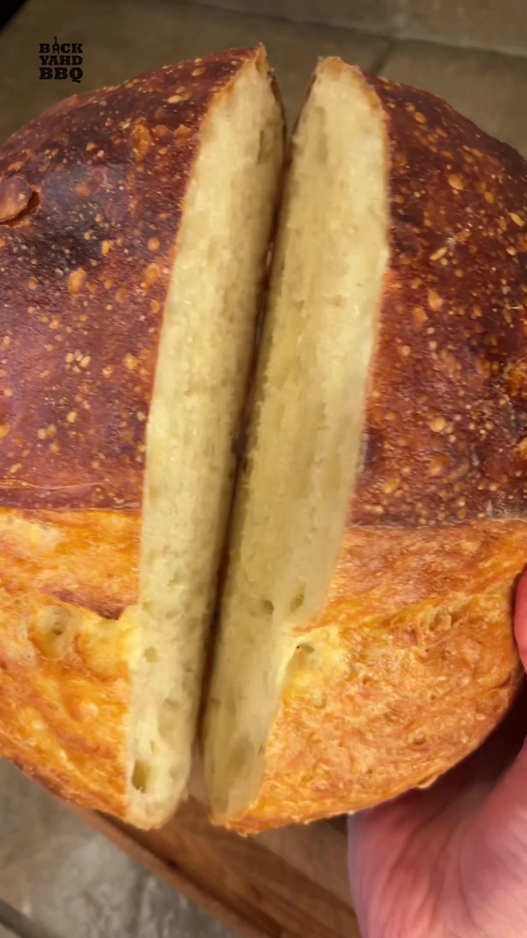 Busy people bread is for those of us who want fresh homemade bread in the morning, but don’t have the time it takes to make proper sourdough bread.  It takes about 24 hours from start to finish, but only a few minutes of hands-on time. In the morning, Combine 400g of flour, 8g of salt, 1g of instant or active dry yeast, and 300g of room temp filtered water.   It will look shaggy like this.  You don’t need to knead it. Cover it with plastic wrap and set on the counter. 30 minutes later, wet your hand, and stretch and fold it like this to help build the gluten.   Let it sit on the counter for 12 hours or until you see air pockets throughout and some bubbling on top. Scrape your dough onto a floured surface and add more flour to the top. Pick up each edge and fold towards the center, flip it over, and tuck the edges. Crumple up some parchment paper, add some flour, and put the dough on it. Put it in a covered bowl and then in the fridge overnight. The next day remove the dough from the fridge and pre-heat your dutch oven at 475 degrees for 30 minutes. Score the dough with a knife or scissors. Carefully remove the dutch oven, put the dough in, and cook covered for 25 minutes. Remove the lid and parchment paper and cook uncovered for an additional 5-15 minutes or until the crust is as dark as you like it. Let it cool on a wire rack for an hour or so and slice in. Props to Jim Lahey for the recipe, my mod is to proof overnight so easy to bake in the morning.  #bread #howto #cooking #nokneadbread