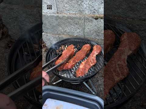 Let’s set up this little grill as a smoker.  I have few smokers and grills, but I wanted to show you that you don’t need fancy grills and tools to get decent results.  If you are thinking about getting into smoking meat, this would be a very affordable way to get started. First find a used Weber Smokey Joe online or on my gear page. Wrap two thirds of the charcoal grate in two layers of foil to help target the airflow towards the coals. Place a wire mesh on the other side if you are using lump charcoal. Separate the two zones with a piece of metal, I use the long end of a charcoal basket. Create a makeshift aluminum water pan and place it on the foil. Add charcoal and wood chips above the wire mesh. Light one of one end of the charcoal - I’m using a torch, but you can use lighter cubes or paper towels and alcohol. The coals will slowly burn to the other end during the cook. Insert your meat and probes. Put on your lid with your top and bottom vents wide open.When it is close to your target temp, close the top and bottom vents about half way to restrict airflow and stabilize the temp. You’ll have to adjust the vents throughout the cook, so keep a close eye on it.  I usually leave the top vent alone and adjust the bottom vent in very small increments. If you find that your meat is drying out you can add water to your pan or spritz. One load of charcoal lasted about 4 hours, so you may have to refill it midway through the cook. I’ll post the full pork butt cook video with this setup soon, so be sure to follow. #bbq #smoker #food #howto #bbqtips #bbqhacks #webergrills